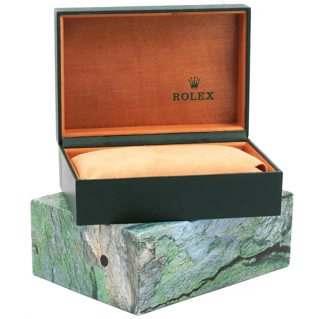 The image shows an open green Rolex box with a pillow inside, used to store the Submariner model watch.