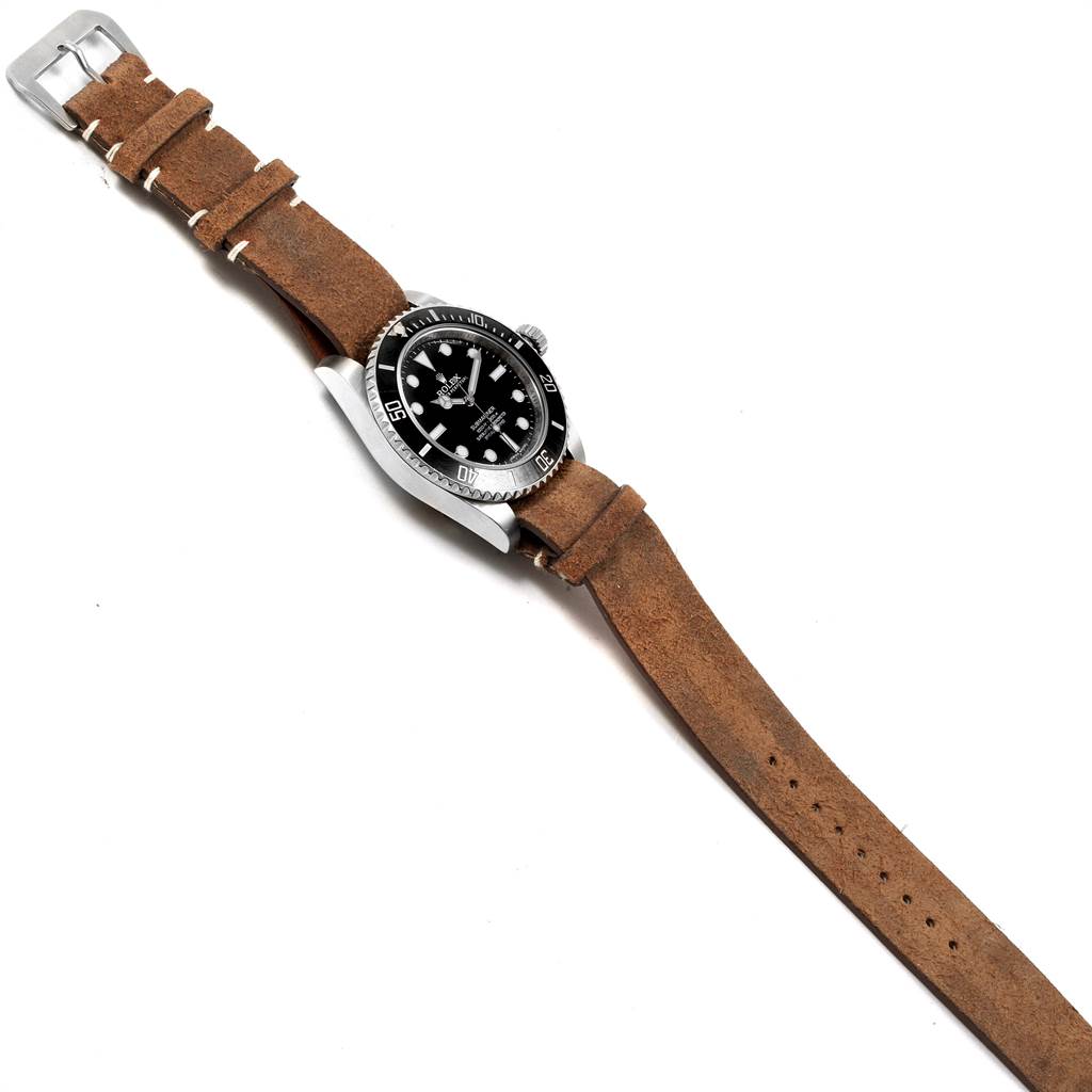 The Rolex Submariner 114060 Men's Stainless Steel Black Dial 114060 Men's Stainless Steel Black Dial watch is shown at an angled top view, highlighting its dial, bezel, casing, and brown leather strap.