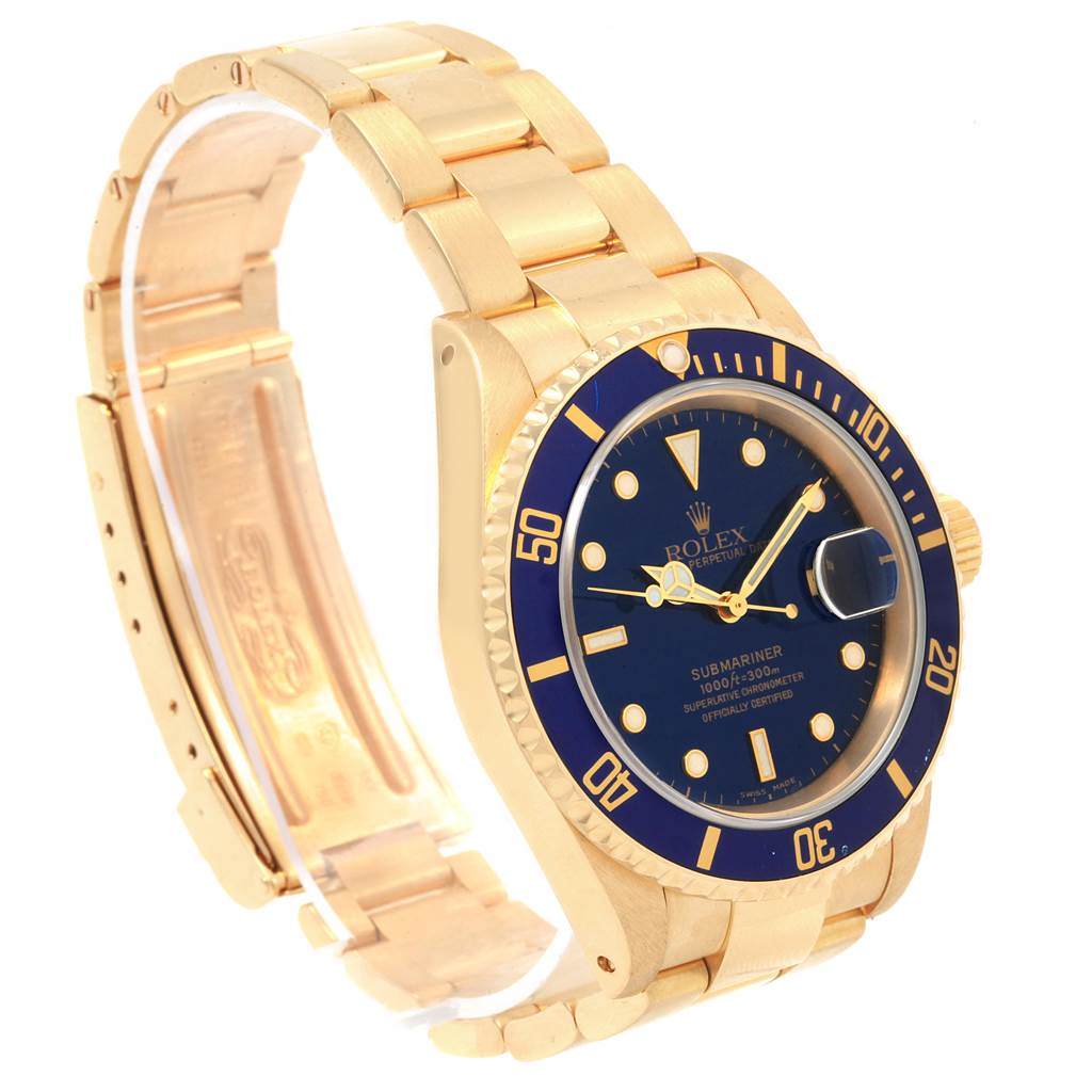 The image shows a Rolex Submariner 16618 Men's Yellow Gold Blue Dial 16618 Men's Yellow Gold Blue Dial watch at an angle displaying its face, bezel, crown, and part of its bracelet.