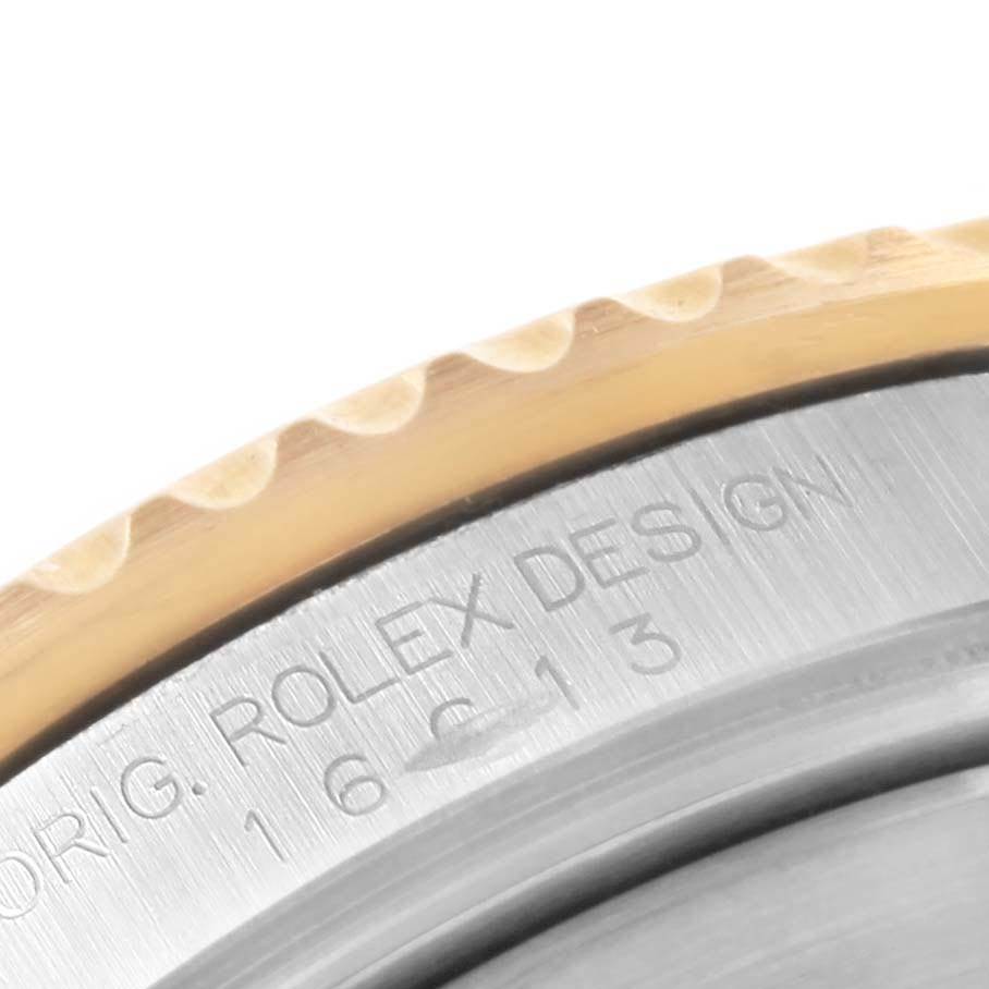 Close-up of the Rolex Submariner 16613 Men's Steel and Gold (two tone) Blue Dial 16613 Men's Steel and Gold (two tone) Blue Dial watch, showing part of the bezel and engraved text on the case side.