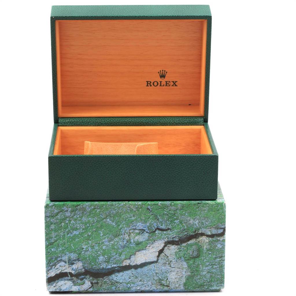 The image shows an open green Rolex box for the Submariner model, displaying the interior padding and the Rolex logo.