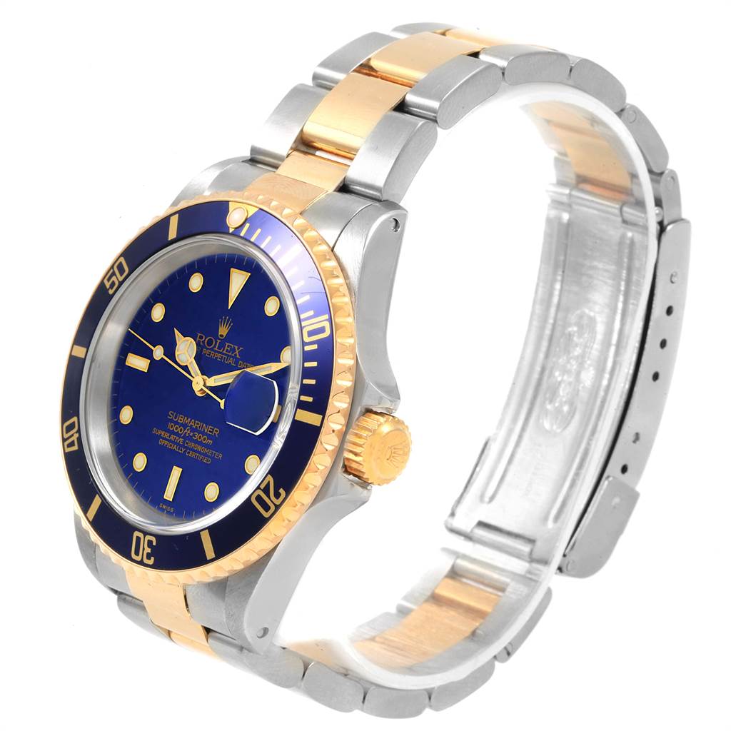 This image shows a Rolex Submariner 16613 Men's Steel and Gold (two tone) Blue Dial 16613 Men's Steel and Gold (two tone) Blue Dial from a three-quarter angle, highlighting the blue dial, bezel, and two-tone bracelet.