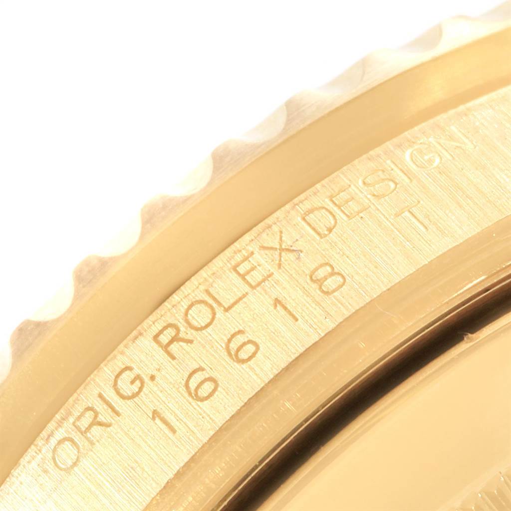 This image shows a close-up of the bezel and engraved part of the casing of a Rolex Submariner 16618 Men's Yellow Gold Black Dial 16618 Men's Yellow Gold Black Dial watch.