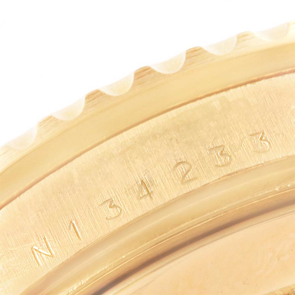 The image shows a close-up of the bezel edge and engraved serial number on a Rolex Submariner 16618 Men's Yellow Gold Black Dial 16618 Men's Yellow Gold Black Dial watch.