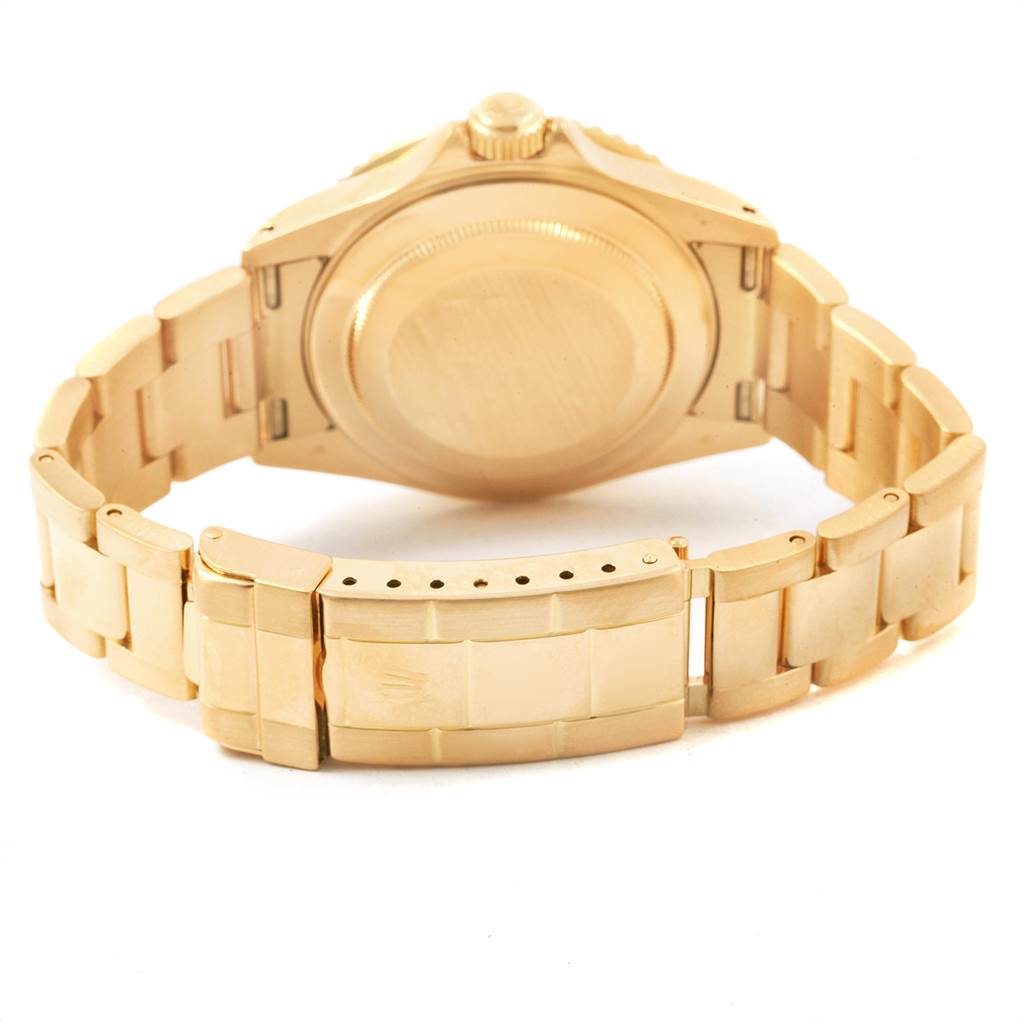The image shows the gold case back and bracelet of a Rolex Submariner 16618 Men's Yellow Gold Black Dial 16618 Men's Yellow Gold Black Dial watch from the rear angle.