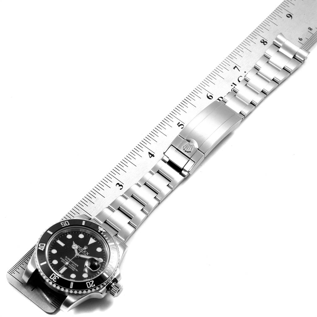 The image shows a Rolex Submariner 116610 Men's Stainless Steel Black Dial 116610 Men's Stainless Steel Black Dial watch laid flat next to a ruler highlighting its face, bezel, and metal bracelet.