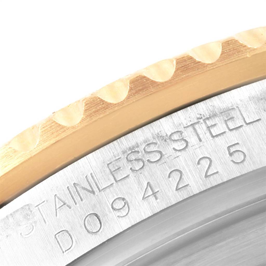 This close-up photo of a Rolex Submariner 16613 Men's Steel and Gold (two tone) Black Dial 16613 Men's Steel and Gold (two tone) Black Dial watch shows the stainless steel case and the edge of the bezel.