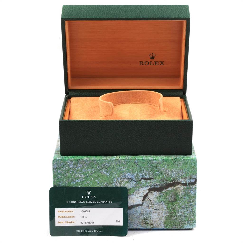 The image shows the open box and an international service guarantee card for a Rolex Submariner 16613 Men's Steel and Gold (two tone) Blue Dial 16613 Men's Steel and Gold (two tone) Blue Dial watch.