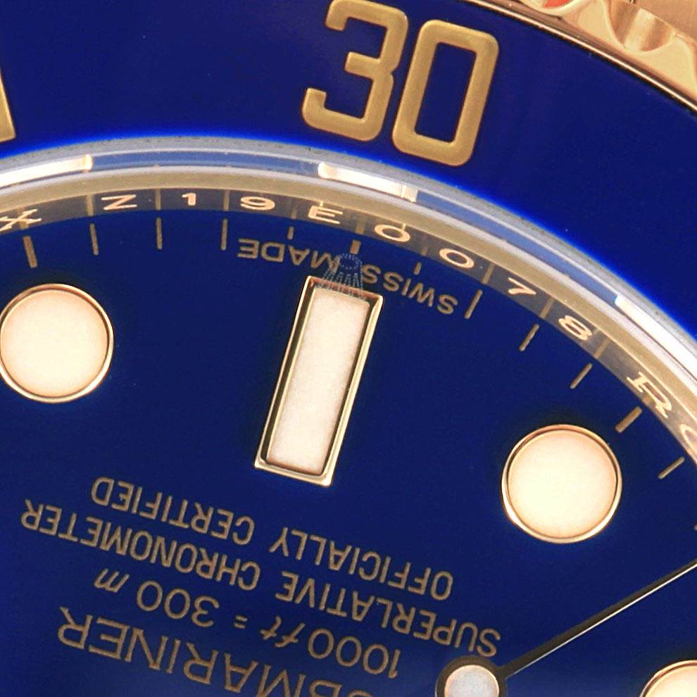 This close-up of the Rolex Submariner 116618 Men's Yellow Gold Blue Dial 116618 Men's Yellow Gold Blue Dial watch shows part of the dial and bezel, focusing on the marker and "Swiss Made" text.