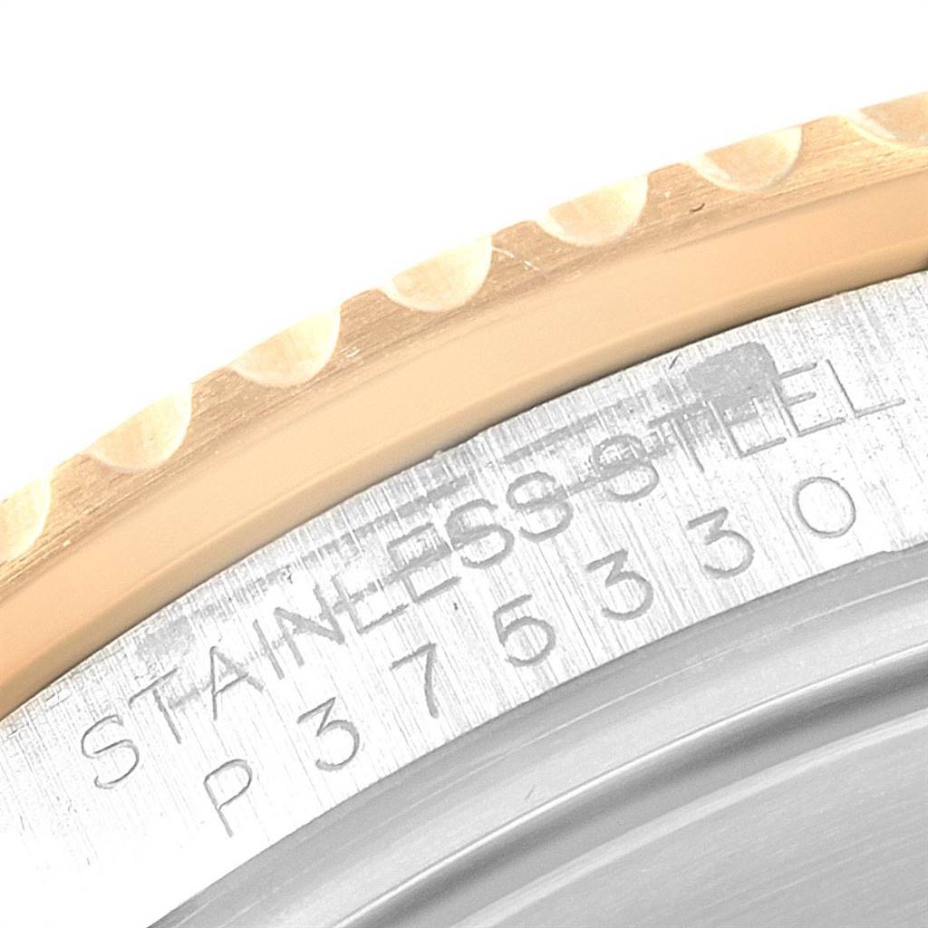 This close-up image shows the edge of the bezel and the engraved case back of a Rolex Submariner 16613 Men's Steel and Gold (two tone) Grey Dial 16613 Men's Steel and Gold (two tone) Grey Dial watch.