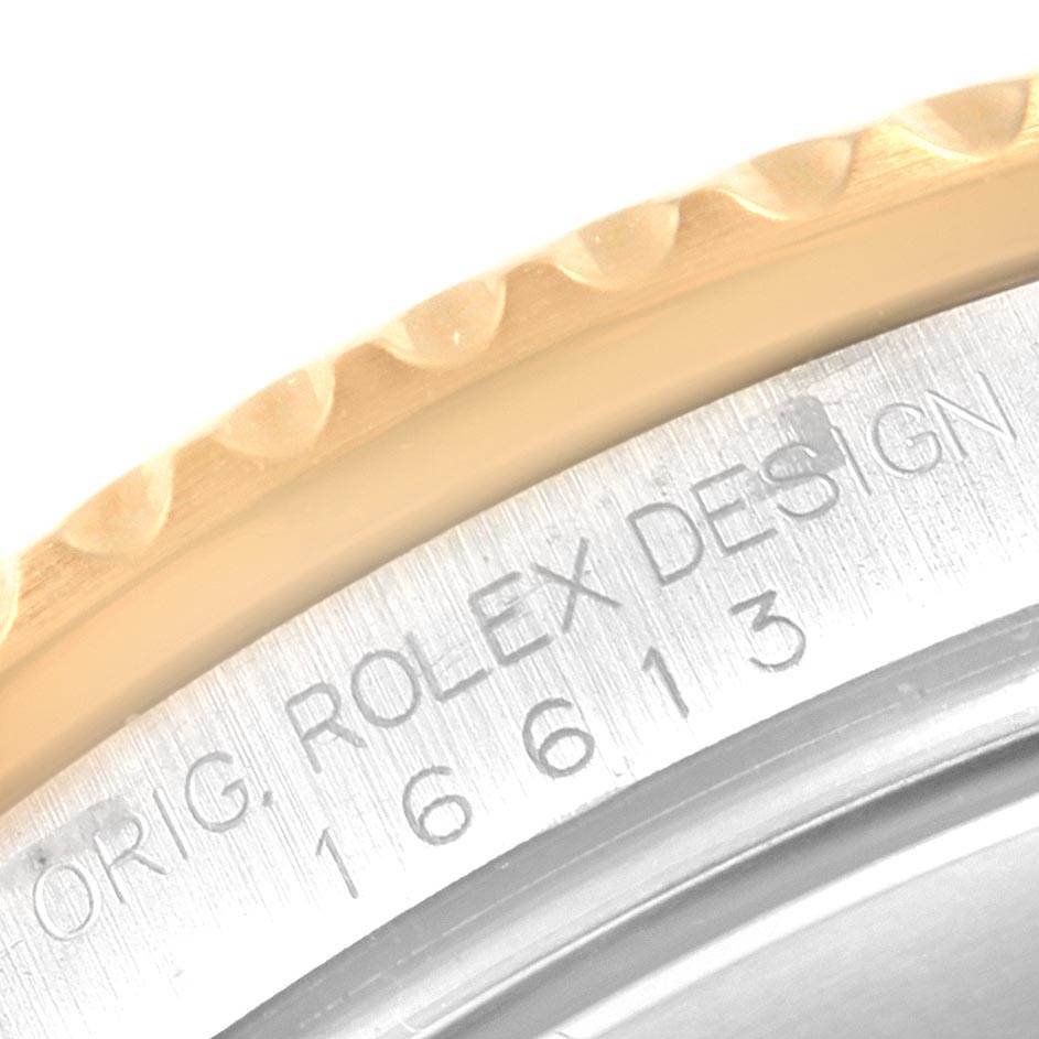 This image shows a close-up view of the edge of the bezel and the engraved text on the side of a Rolex Submariner 16613 Men's Steel and Gold (two tone) Grey Dial 16613 Men's Steel and Gold (two tone) Grey Dial watch.