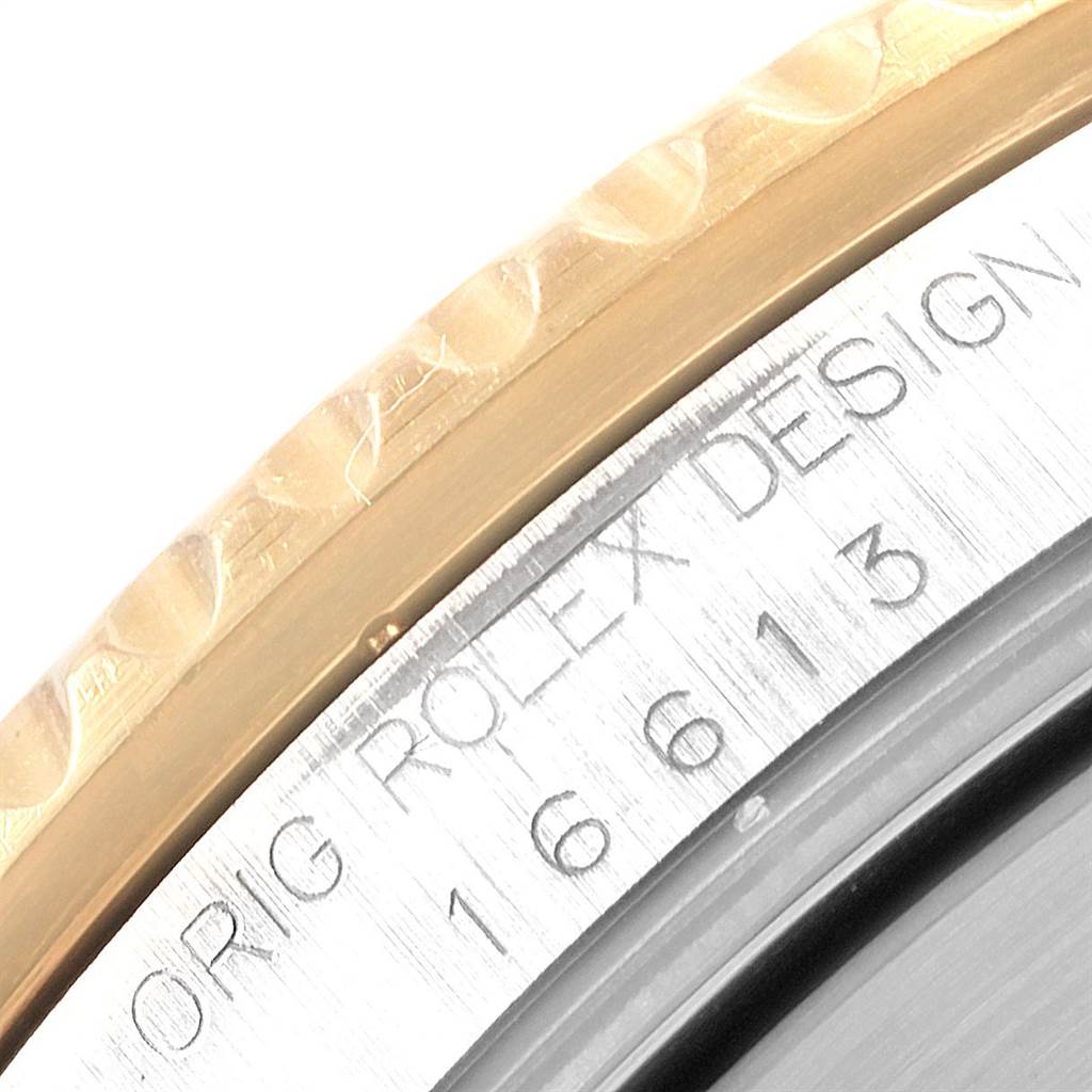 Close-up of Rolex Submariner 16613 Men's Steel and Gold (two tone) Blue Dial 16613 Men's Steel and Gold (two tone) Blue Dial model showing part of the metal bezel and engraved serial number on the case.