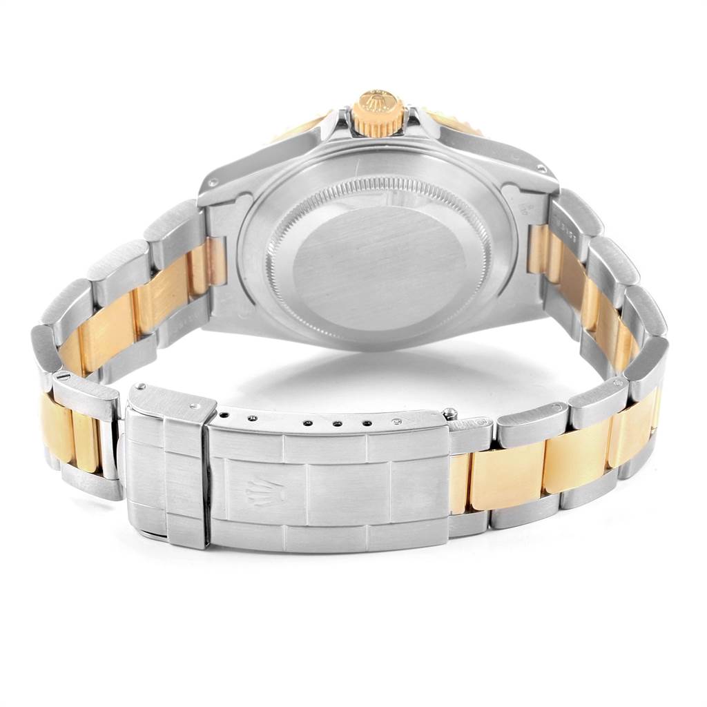 The image shows the back view of the Rolex Submariner 16613 Men's Steel and Gold (two tone) Blue Dial 16613 Men's Steel and Gold (two tone) Blue Dial, highlighting its case back, crown, and two-tone bracelet.