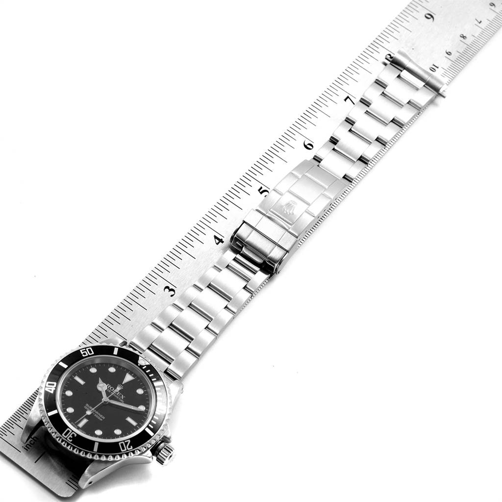 This image shows a Rolex Submariner 14060 Men's Stainless Steel Black Dial 14060 Men's Stainless Steel Black Dial watch viewed from a top-down angle, alongside a ruler measuring its stainless steel bracelet.