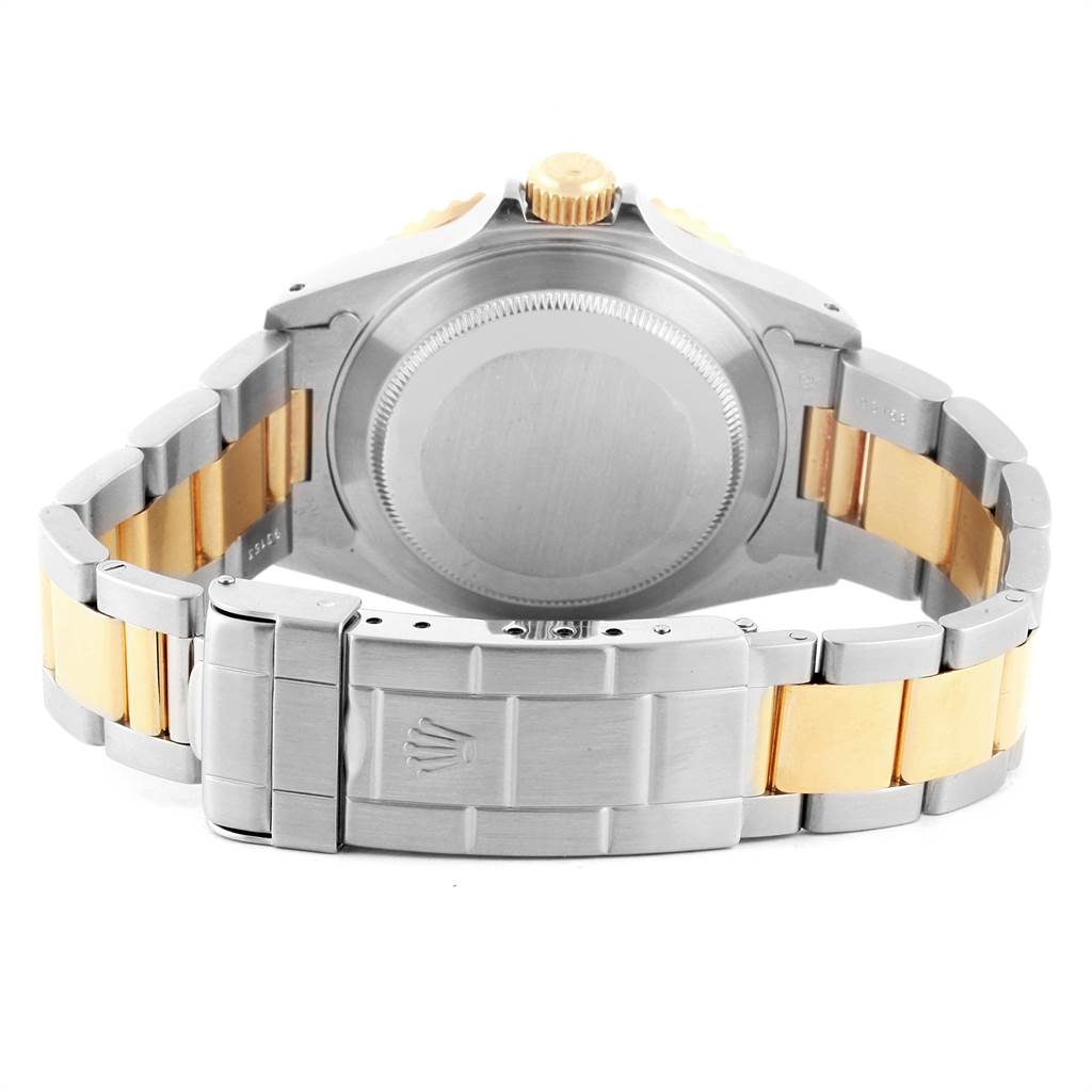 The image shows the back view of a Rolex Submariner 16613 Men's Steel and Gold (two tone) Blue Dial 16613 Men's Steel and Gold (two tone) Blue Dial, highlighting the case back, crown, and two-tone bracelet.