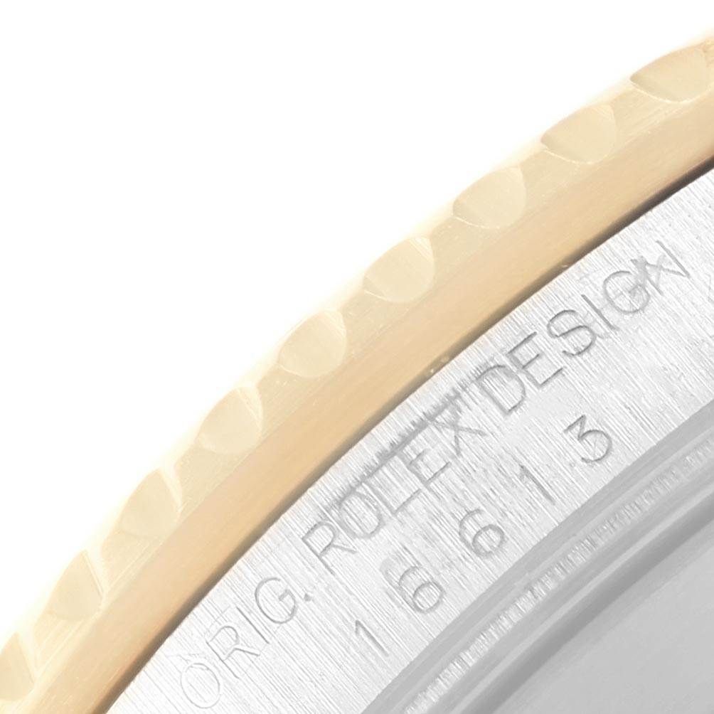 This image shows a close-up of the edge of a Rolex Submariner 16613 Men's Steel and Gold (two tone) Blue Dial 16613 Men's Steel and Gold (two tone) Blue Dial watch, displaying part of the bezel and engraved case back.