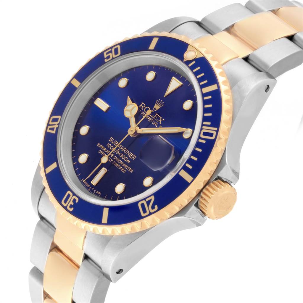 The image shows a Rolex Submariner 16613 Men's Steel and Gold (two tone) Blue Dial 16613 Men's Steel and Gold (two tone) Blue Dial watch at an angled close-up, displaying the blue dial, gold bezel, and portion of the bracelet.