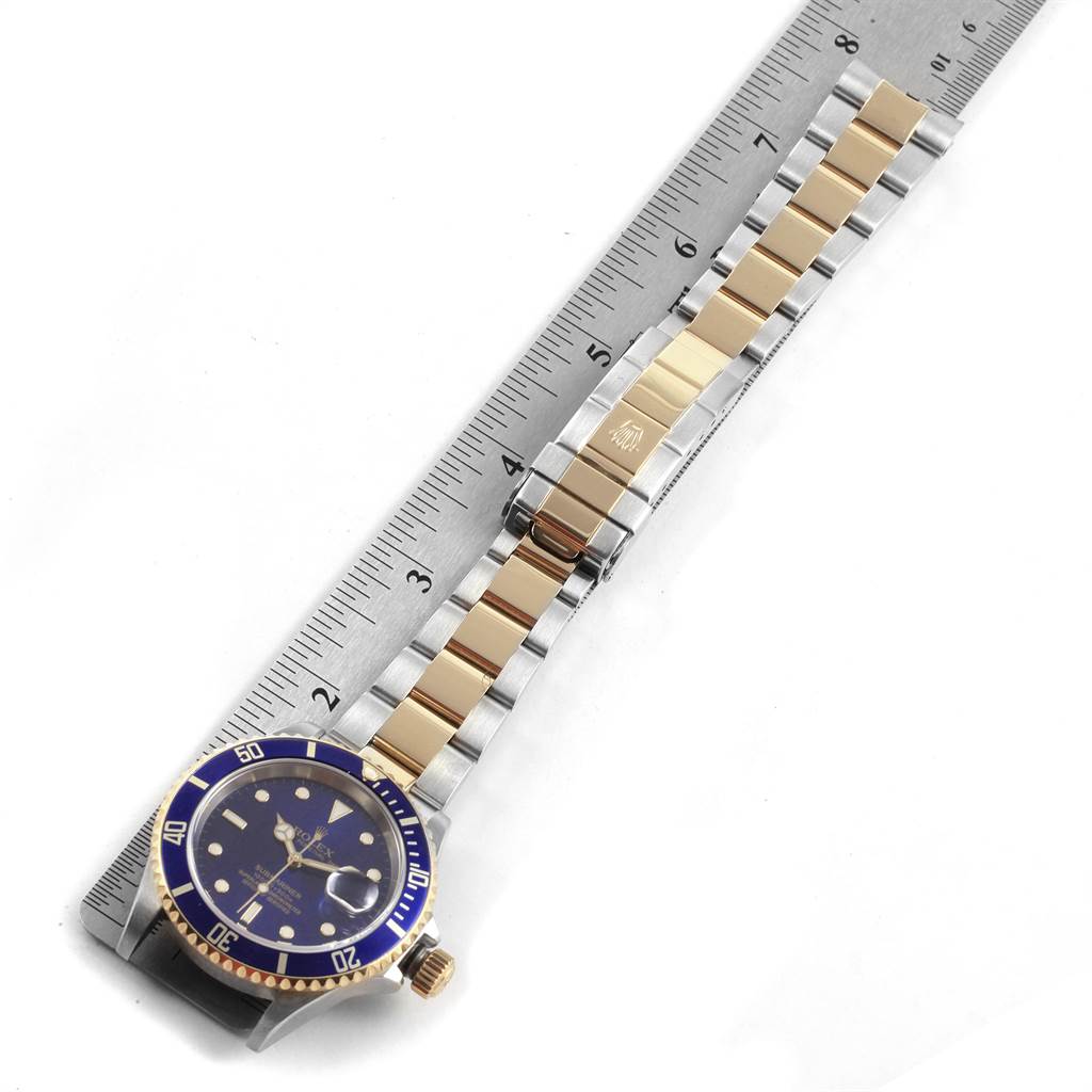 The Rolex Submariner 16613 Men's Steel and Gold (two tone) Blue Dial 16613 Men's Steel and Gold (two tone) Blue Dial watch is shown from a top-down angle, displaying the bracelet, clasp, and face.