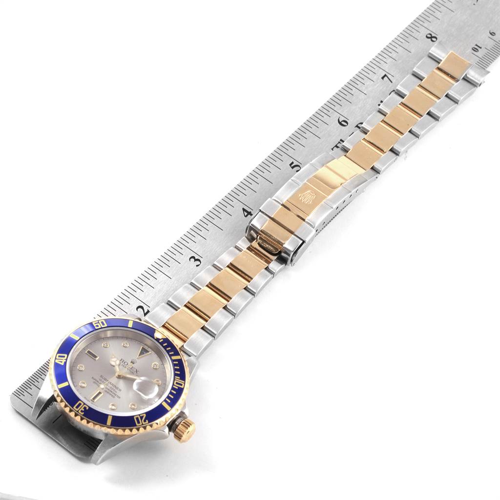 The image shows the face and band of a Rolex Submariner 16613 Men's Steel and Gold (two tone) Grey Dial 16613 Men's Steel and Gold (two tone) Grey Dial watch, measured against a ruler.