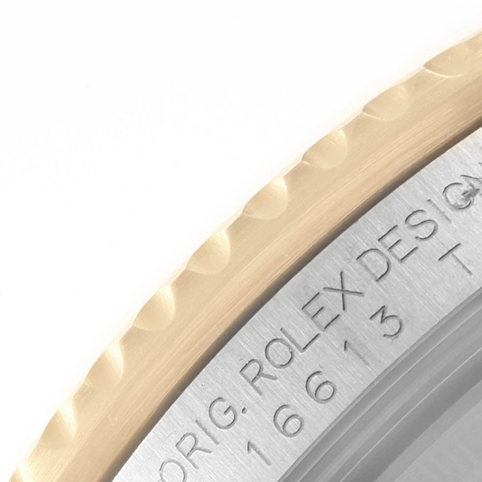 This close-up image shows the edge of the bezel and part of the engraving on the case back of a Rolex Submariner 16613 Men's Steel and Gold (two tone) Grey Dial 16613 Men's Steel and Gold (two tone) Grey Dial watch.