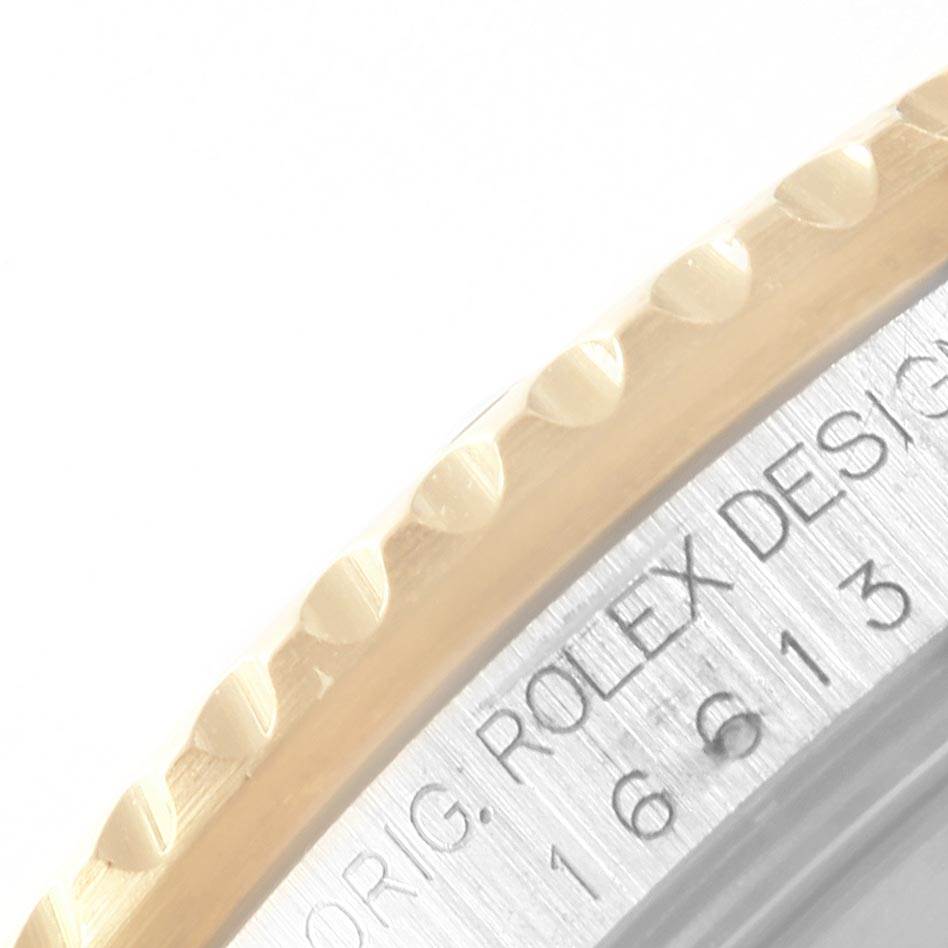 The image shows a close-up of the side of the bezel and the engraved part of the case of a Rolex Submariner 16613 Men's Steel and Gold (two tone) Blue Dial 16613 Men's Steel and Gold (two tone) Blue Dial watch.