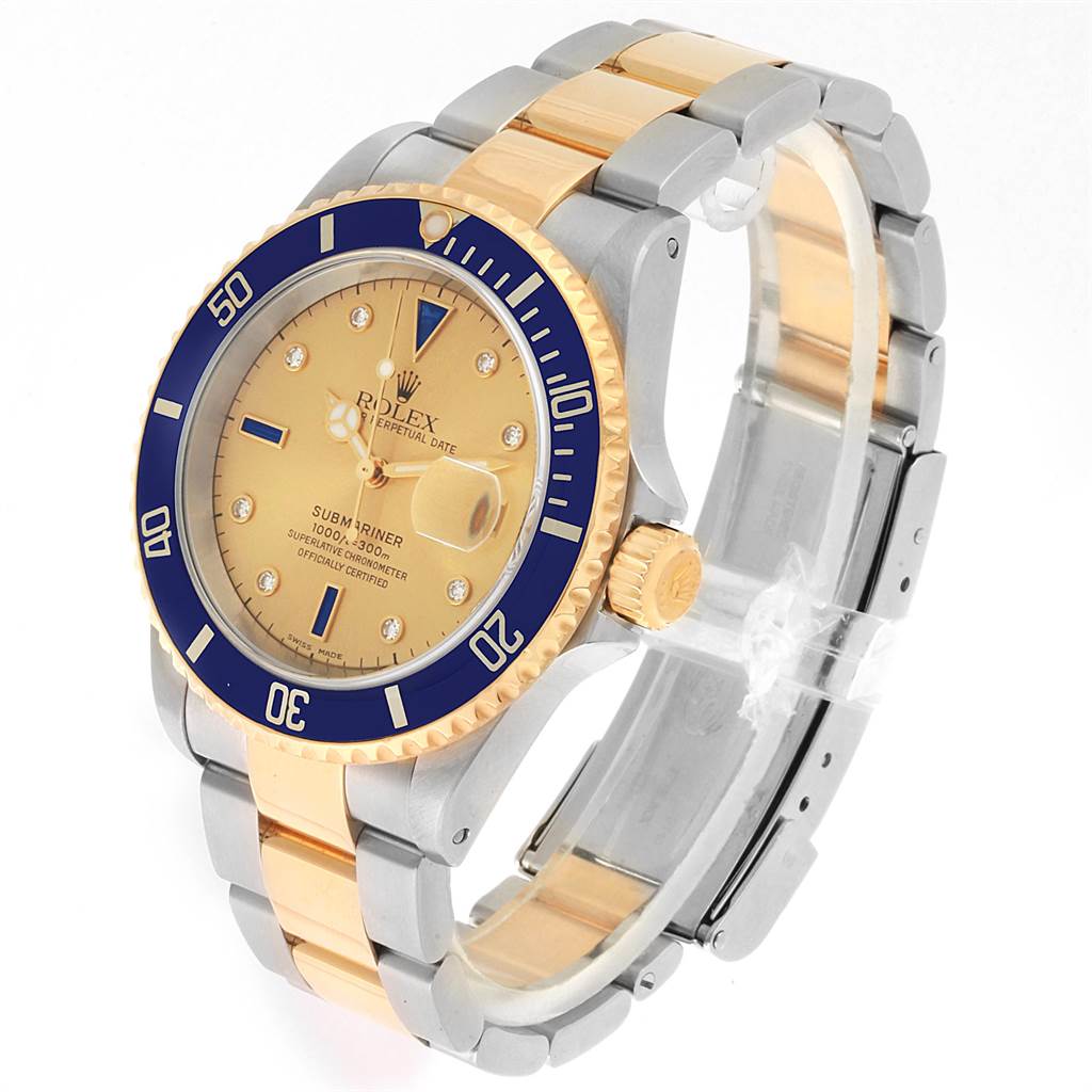 The Rolex Submariner 16613 Men
s Steel and Gold (two tone) Champagne Dial 16613 Men
s Steel and Gold (two tone) Champagne Dial is shown at an angle highlighting the gold and silver bracelet, blue bezel, and champagne dial.