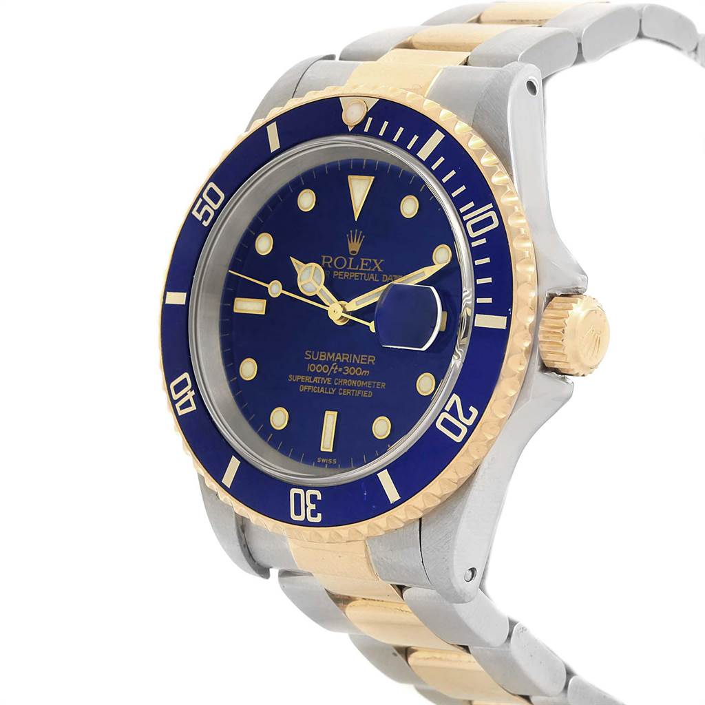 The image shows a Rolex Submariner 16613 Men's Steel and Gold (two tone) Blue Dial 16613 Men's Steel and Gold (two tone) Blue Dial watch at a 3/4 angle, highlighting its blue dial and two-tone bracelet.