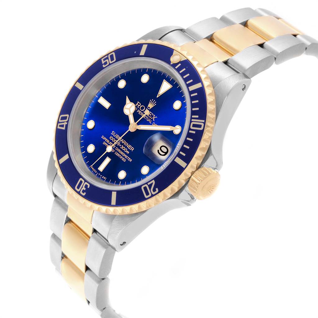 The image shows a Rolex Submariner 16613 Men's Steel and Gold (two tone) Blue Dial 16613 Men's Steel and Gold (two tone) Blue Dial watch at an angled view, highlighting its blue dial, date window, bezel, and two-tone metal bracelet.