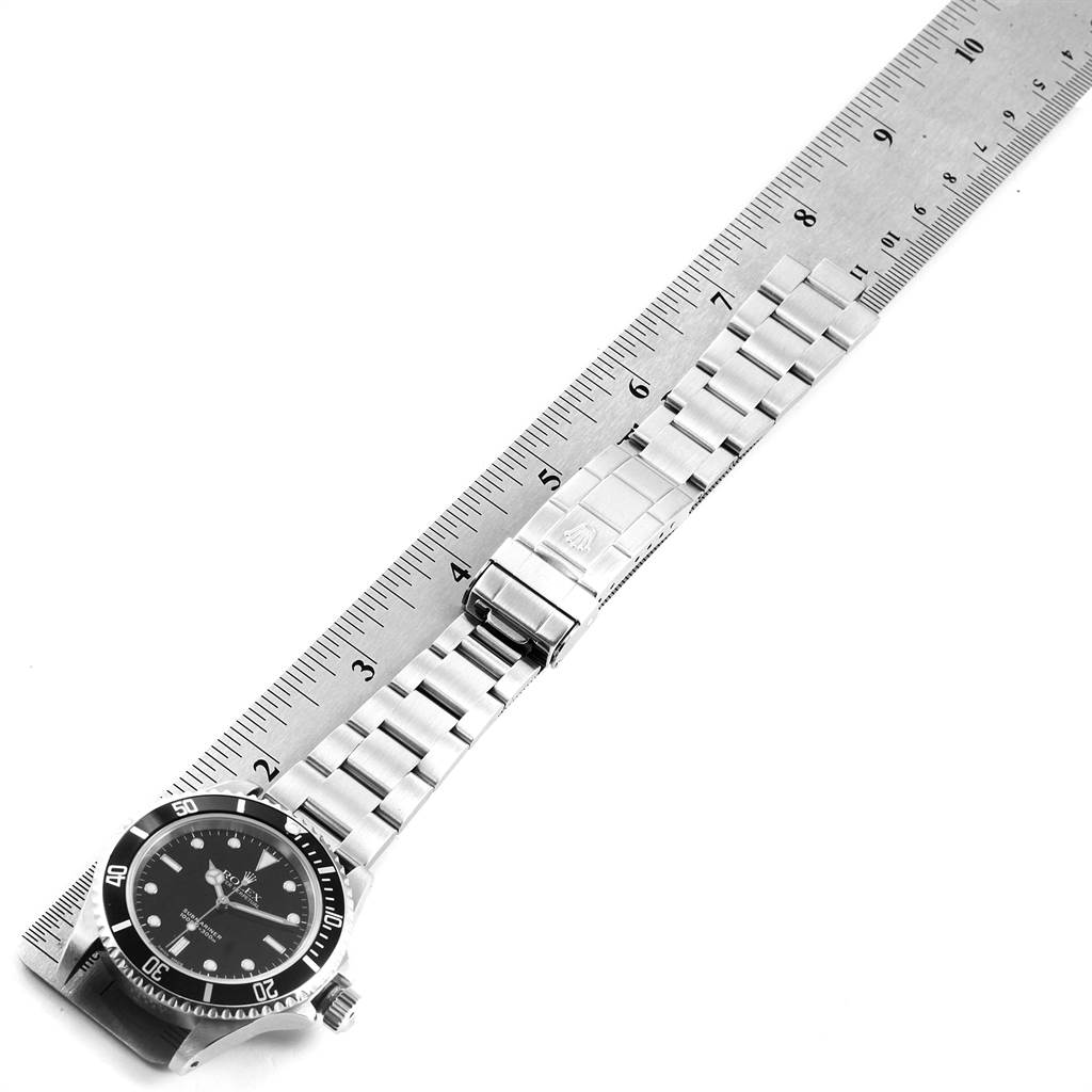 The image shows a Rolex Submariner 14060 Men's Stainless Steel Black Dial 14060 Men's Stainless Steel Black Dial watch lying flat with its bracelet extended alongside a ruler for measurement.