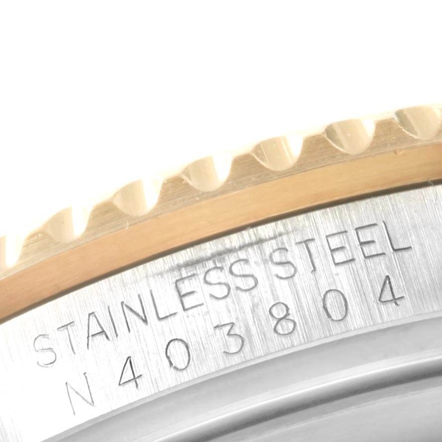 This image shows a close-up of the serial number engraving and part of the bezel on a Rolex Submariner 16613 Men's Steel and Gold (two tone) Blue Dial 16613 Men's Steel and Gold (two tone) Blue Dial.