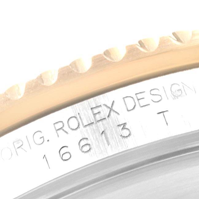 This image shows a close-up of the engraved case side of a Rolex Submariner 16613 Men's Steel and Gold (two tone) Black Dial 16613 Men's Steel and Gold (two tone) Black Dial model, focusing on its serial number and part of the bezel.