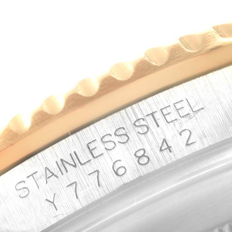 This image shows a close-up of the serial number and a portion of the bezel of a Rolex Submariner 16613 Men's Steel and Gold (two tone) Blue Dial 16613 Men's Steel and Gold (two tone) Blue Dial watch.