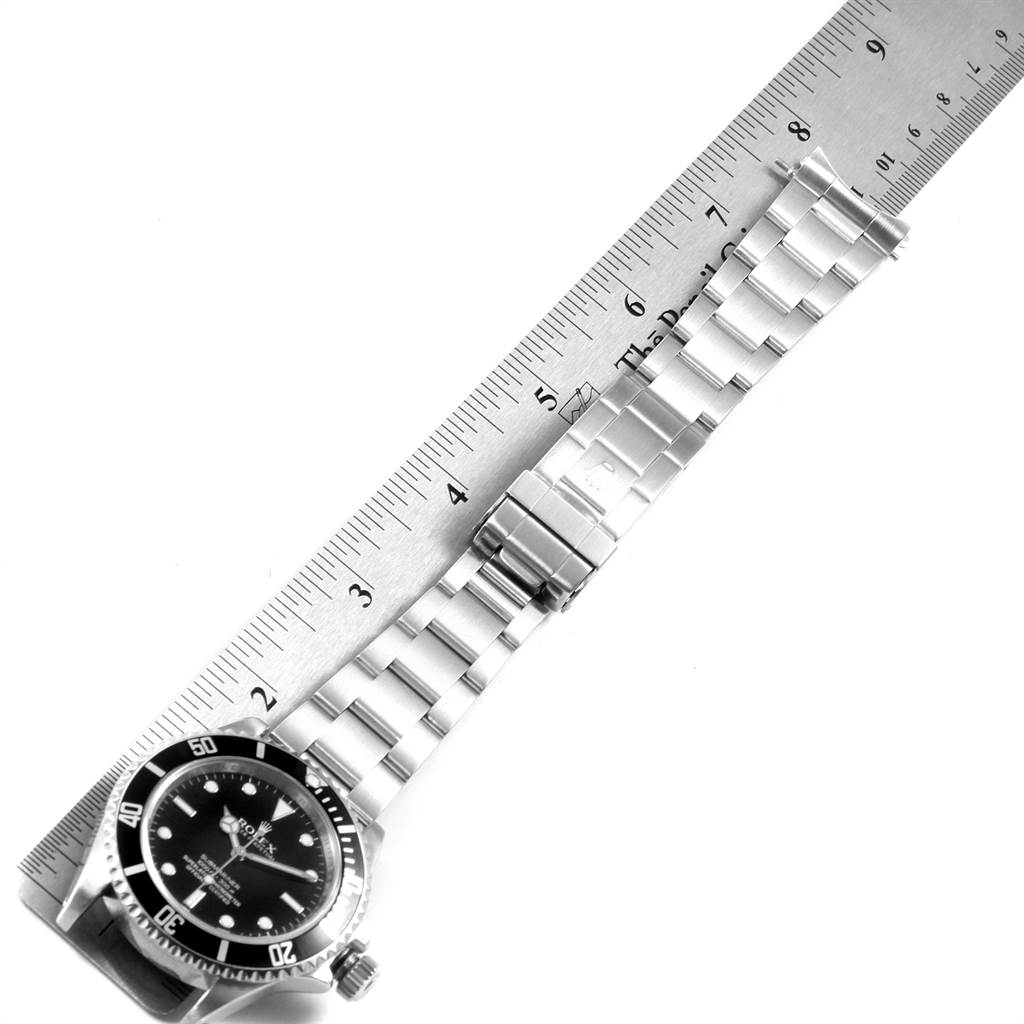 The image shows a top-down view of a Rolex Submariner 14060 Men's Stainless Steel Black Dial 14060 Men's Stainless Steel Black Dial watch with its bracelet extended next to a ruler.