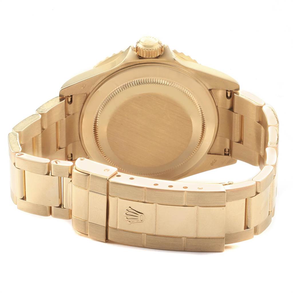 The image shows the back view of a Rolex Submariner 16618 Men
s Yellow Gold Black Dial 16618 Men
s Yellow Gold Black Dial watch, highlighting its case back, crown, and bracelet clasp.