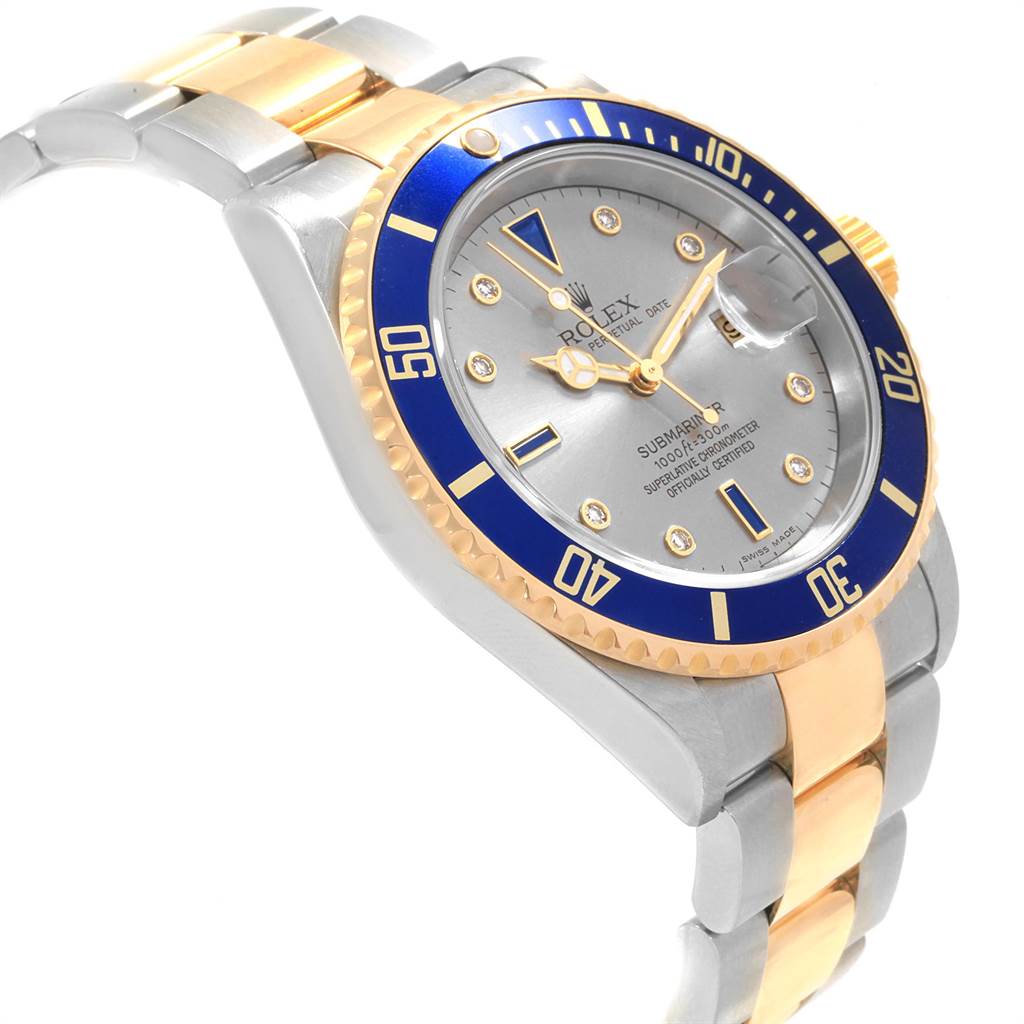 The image shows a Rolex Submariner 16613 Men
s Steel and Gold (two tone) Grey Dial 16613 Men
s Steel and Gold (two tone) Grey Dial watch at a slight angle, displaying its blue bezel, silver dial, and two-tone (gold and silver) bracelet.