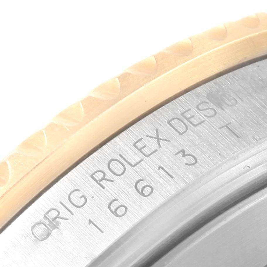 The image shows a close-up of the case back and bezel edge of a Rolex Submariner 16613 Men
s Steel and Gold (two tone) Grey Dial 16613 Men
s Steel and Gold (two tone) Grey Dial watch, revealing part of its model number and branding.