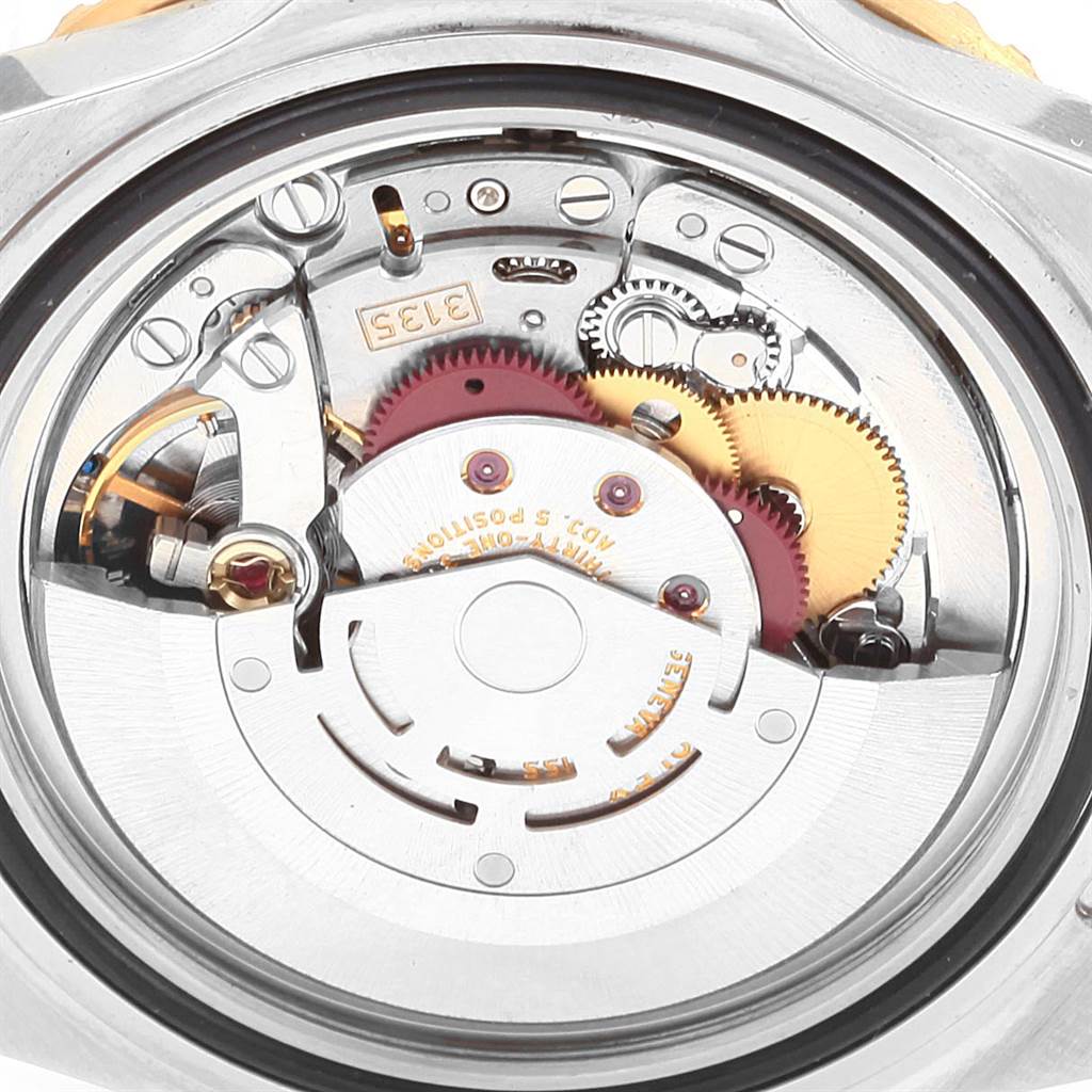 The image shows the intricate internal mechanism of a Rolex Submariner 16613 Men
s Steel and Gold (two tone) Grey Dial 16613 Men
s Steel and Gold (two tone) Grey Dial watch from a close-up angle.