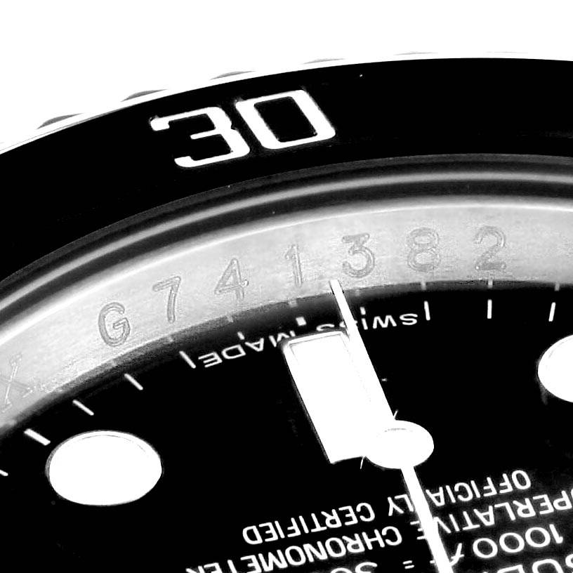 The image shows a close-up of the bezel, dial, and partially visible serial number of a Rolex Submariner 114060 Men
s Stainless Steel Black Dial 114060 Men
s Stainless Steel Black Dial watch.