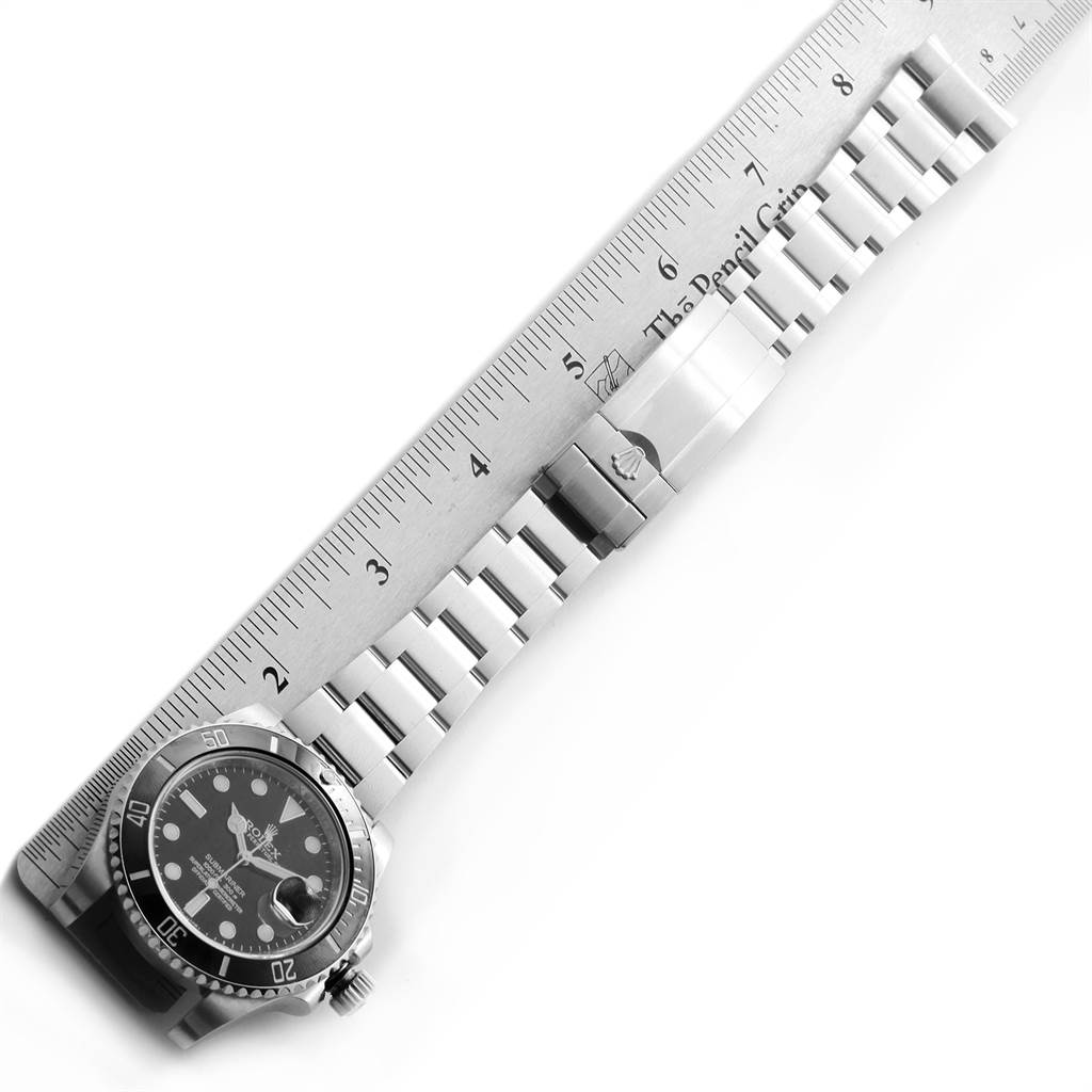 The image shows a Rolex Submariner 116610 Men
s Stainless Steel Black Dial 116610 Men
s Stainless Steel Black Dial watch laid flat alongside a ruler, highlighting the watch bracelet and clasp.