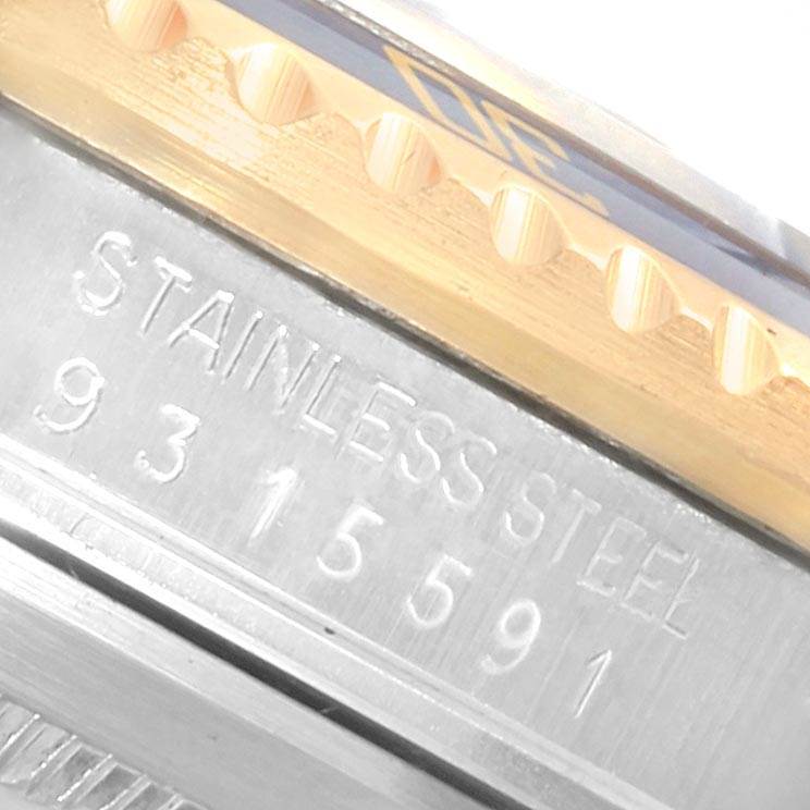 The image shows a close-up of the Rolex Submariner 16803 Men
s Steel and Gold (two tone) Blue Dial 16803 Men
s Steel and Gold (two tone) Blue Dial
s stainless steel case with visible engraving and part of the bezel.