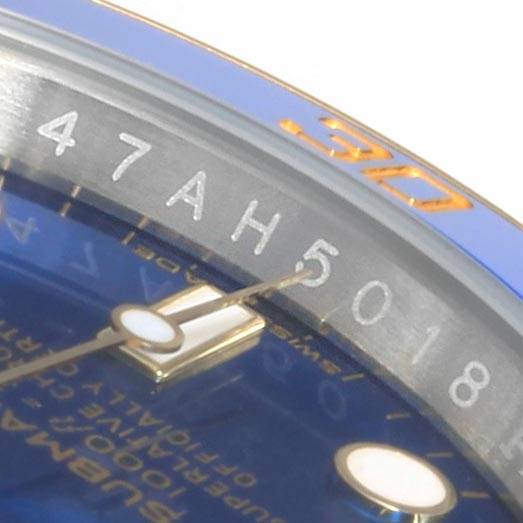 This close-up angle of the Rolex Submariner 116613 Men
s Steel and Gold (two tone) Blue Dial 116613 Men
s Steel and Gold (two tone) Blue Dial shows part of the watch face, serial number, and luminescent markers.