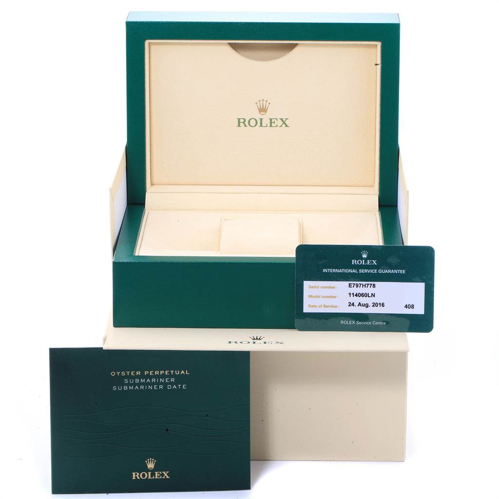 This image shows an open green Rolex box for the Submariner model, along with its service guarantee card and manual.