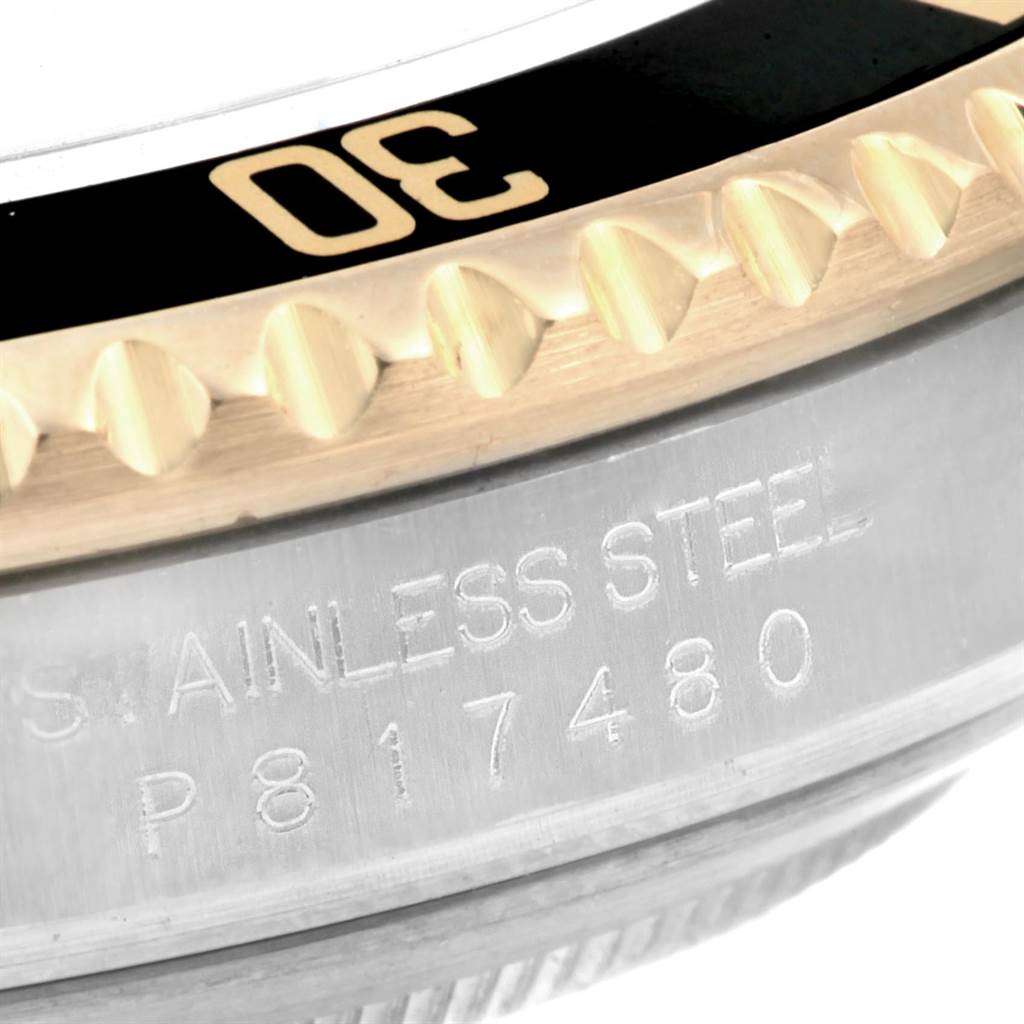 This image shows a close-up of the bezel and part of the case of a Rolex Submariner 16613 Men
s Steel and Gold (two tone) Black Dial 16613 Men
s Steel and Gold (two tone) Black Dial watch, highlighting the "30" mark and "stainless steel" engraving.