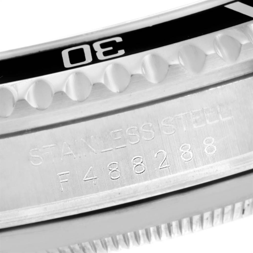 This image shows a close-up of the Rolex Submariner 16610 Men
s Stainless Steel Black Dial 16610 Men
s Stainless Steel Black Dial
s side, focusing on the bezel and engraved serial number on the stainless steel case.