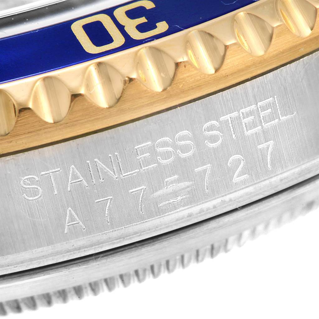 This image shows a close-up of the bezel and engraved stainless steel case of a Rolex Submariner 16613 Men
s Steel and Gold (two tone) Blue Dial 16613 Men
s Steel and Gold (two tone) Blue Dial watch.