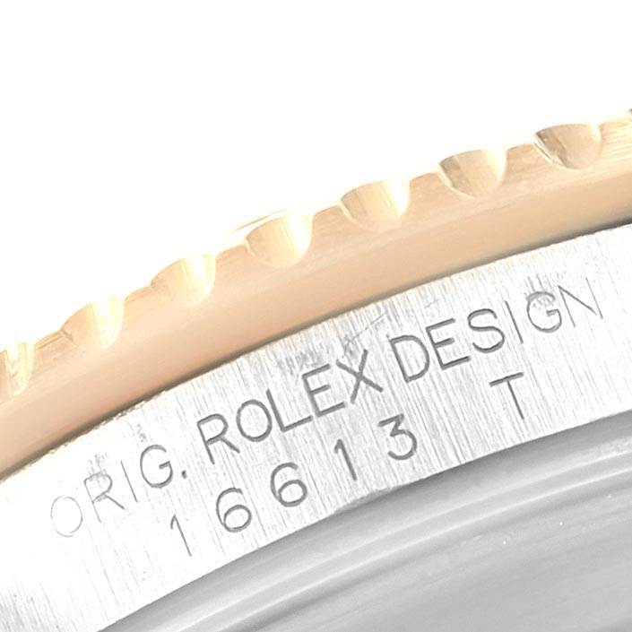 The image shows a close-up of the case side, with “ORIG. ROLEX DESIGN 16613” engraved on the Rolex Submariner 16613 Men
s Steel and Gold (two tone) Grey Dial 16613 Men
s Steel and Gold (two tone) Grey Dial watch.
