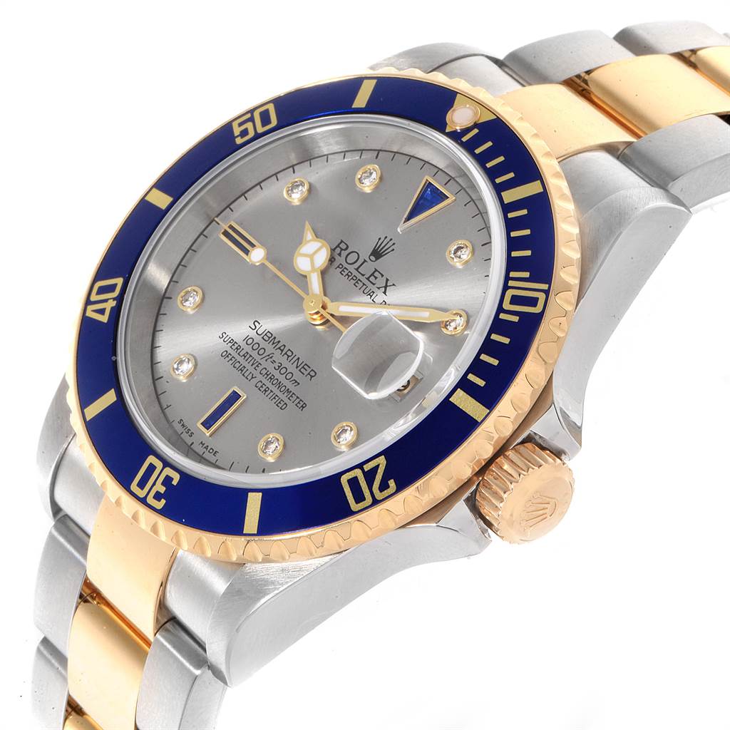 The image shows a Rolex Submariner 16613 Men
s Steel and Gold (two tone) Grey Dial 16613 Men
s Steel and Gold (two tone) Grey Dial watch at an angle highlighting the face, bezel, crown, and bracelet.