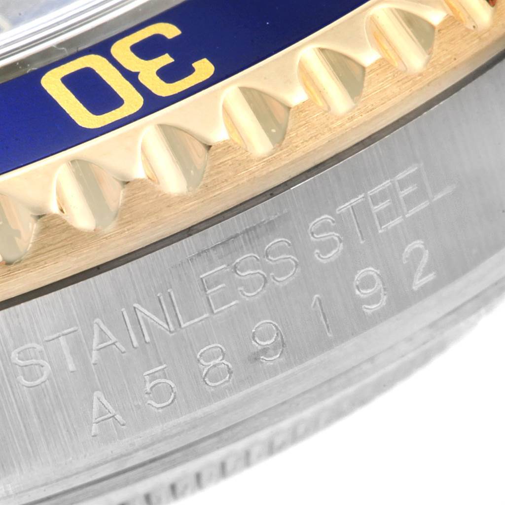 The image shows a close-up of the bezel and case of a Rolex Submariner 16613 Men
s Steel and Gold (two tone) Blue Dial 16613 Men
s Steel and Gold (two tone) Blue Dial watch, highlighting the "30" marking and "STAINLESS STEEL" engraving.