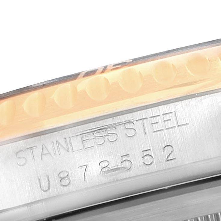 The image shows a close-up of the side of a Rolex Submariner 16613 Men
s Steel and Gold (two tone) Blue Dial 16613 Men
s Steel and Gold (two tone) Blue Dial watch, highlighting the stainless steel material and serial number.