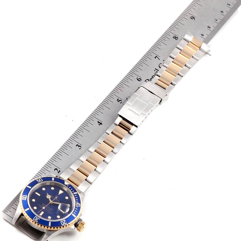 The image shows the Rolex Submariner 16613 Men
s Steel and Gold (two tone) Blue Dial 16613 Men
s Steel and Gold (two tone) Blue Dial watch at an angle, featuring the face, bezel, and bracelet measured against a ruler.